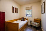 This charming bedroom features a cozy wooden daybed, perfect for relaxation or as a guest sleeping area.