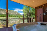 Experience ultimate relaxation with this stunning hot tub, offering breathtaking mountain views and a serene natural backdrop.