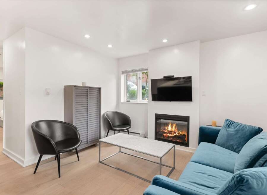 Cozy living room featuring a modern fireplace with a television mounted above.