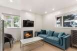 Cozy up by the fireplace in this inviting living room, featuring a plush teal sofa perfect for relaxation.