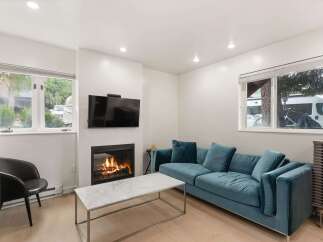 Cozy up by the fireplace in this inviting living room, featuring a plush teal sofa perfect for relaxation.