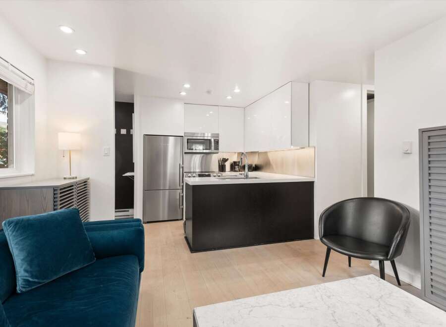 Experience modern living in this stylish studio apartment featuring a sleek, contemporary kitchen with high-gloss cabinetry and stainless steel appliances.