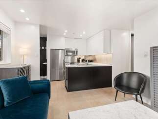 Experience modern living in this stylish studio apartment featuring a sleek, contemporary kitchen with high-gloss cabinetry and stainless steel appliances.