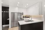 Experience modern living in this sleek kitchen featuring stainless steel appliances, including a refrigerator, microwave, and oven.