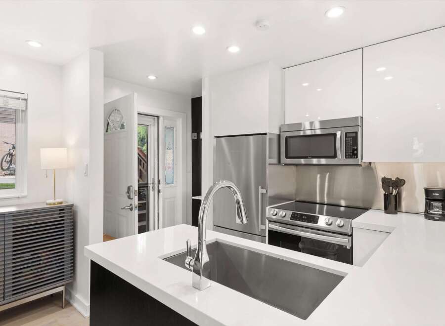 Experience modern living in this sleek kitchen featuring high-end stainless steel appliances, including a refrigerator, microwave, and a smooth-top range.