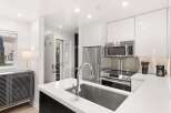 Experience modern living in this sleek kitchen featuring high-end stainless steel appliances, including a refrigerator, microwave, and a smooth-top range.