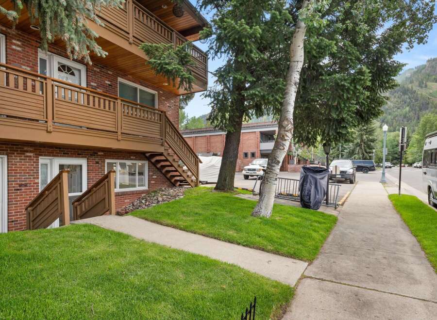 Discover this charming brick building featuring multi-level balconies with rich wooden railings, perfect for enjoying the mountain views.