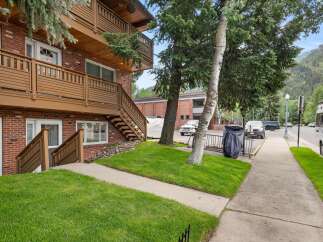 Discover this charming brick building featuring multi-level balconies with rich wooden railings, perfect for enjoying the mountain views.