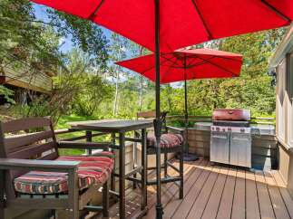 Enjoy outdoor living on this spacious deck, complete with a high-top table and chairs perfect for al fresco dining.