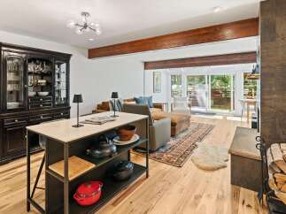 Experience open-concept living with this beautifully appointed space, featuring a modern kitchen island and a cozy living area.