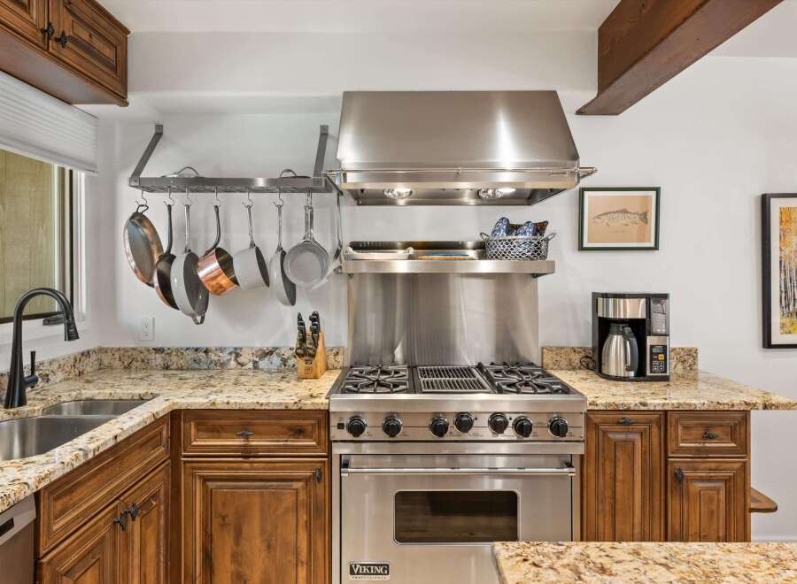 Experience culinary excellence in this stunning kitchen, featuring a professional-grade Viking range and a convenient pot rack for easy access to your cookware.
