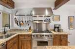 Experience culinary excellence in this stunning kitchen, featuring a professional-grade Viking range and a convenient pot rack for easy access to your cookware.