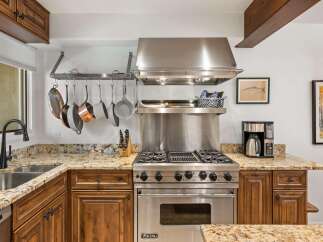 Experience culinary excellence in this stunning kitchen, featuring a professional-grade Viking range and a convenient pot rack for easy access to your cookware.