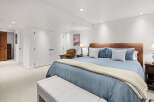 This spacious bedroom features a comfortable king-size bed with a plush blue comforter and a cozy knit throw.
