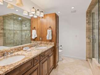 Experience luxury in this stunning bathroom featuring a spacious double vanity with granite countertops and ample storage.