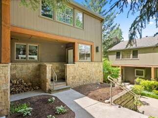 Charming mountain townhome featuring a rustic stone facade and warm wood accents.