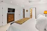 This master bedroom offers a luxurious retreat with a plush white duvet and a striking faux fur throw.