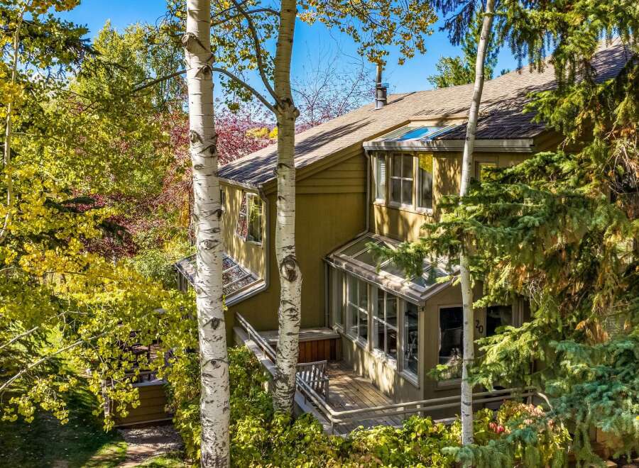 Nestled amidst vibrant autumn foliage, this charming home offers a serene retreat.