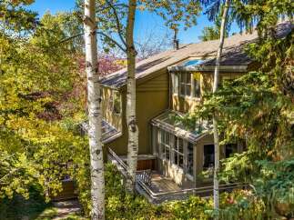 Nestled amidst vibrant autumn foliage, this charming home offers a serene retreat.