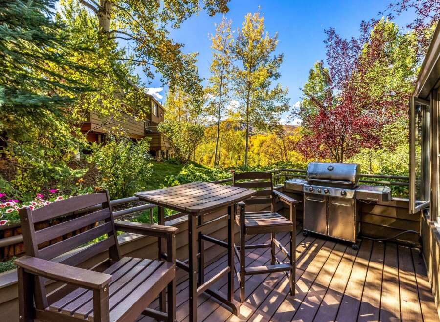 Enjoy outdoor living on this spacious deck, complete with a grill and dining set, perfect for entertaining.