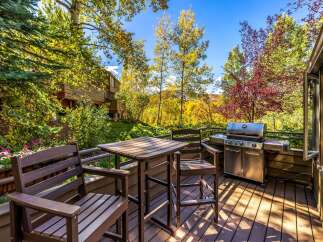 Enjoy outdoor living on this spacious deck, complete with a grill and dining set, perfect for entertaining.