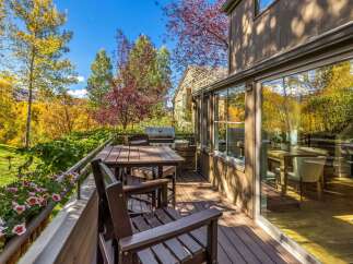 Enjoy the stunning autumn foliage from this beautiful deck, complete with a dining set and a grill.