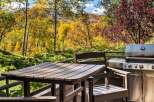 Enjoy the vibrant autumn foliage from this stunning deck, complete with a Weber grill and outdoor dining set.