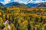 Experience the breathtaking beauty of autumn in this stunning mountain landscape, showcasing vibrant fall foliage against a backdrop of majestic peaks.