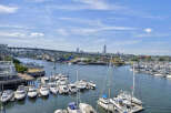 Experience waterfront living at its finest with this stunning property offering panoramic views of a bustling marina and a picturesque city skyline.