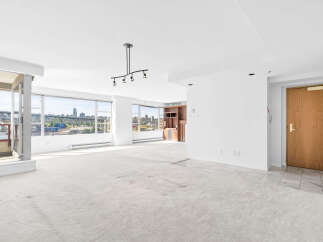 Experience breathtaking city and water views from this expansive living space, featuring floor-to-ceiling windows that flood the room with natural light.
