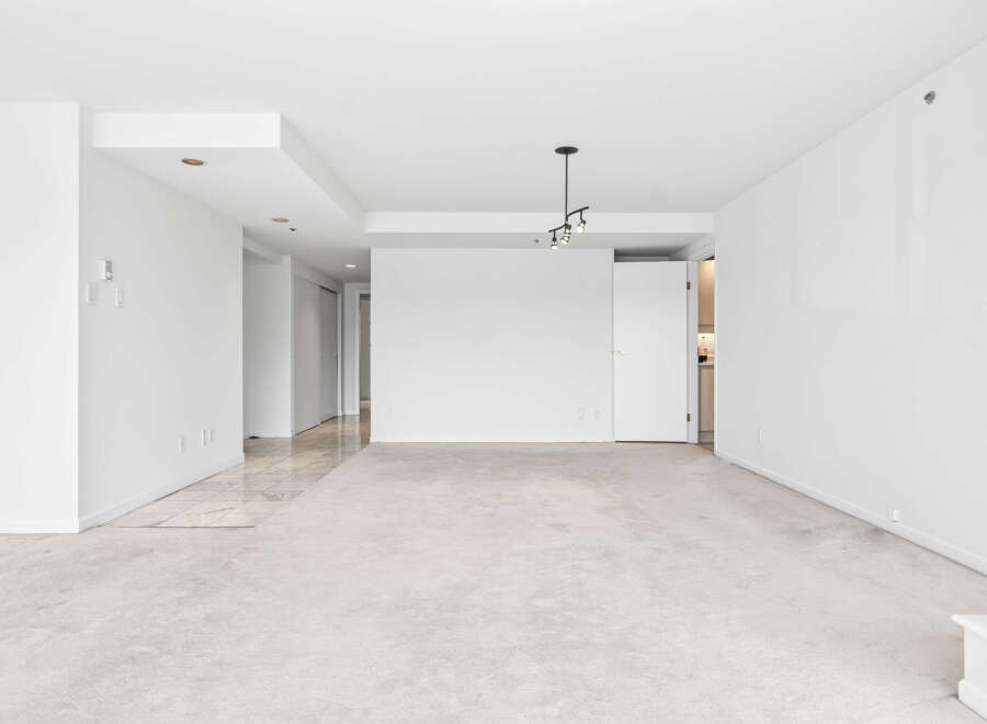 This spacious, unfurnished living area boasts a neutral color palette, making it a blank canvas for your personal style.