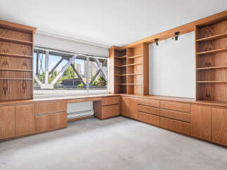 This spacious room features custom-built wooden cabinetry and shelving, offering ample storage and display space.