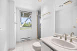 This bright and airy bathroom features a spacious vanity with a double sink and elegant brushed nickel fixtures.