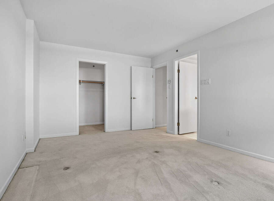 This spacious room features neutral carpeting and ample closet space, perfect for storage.