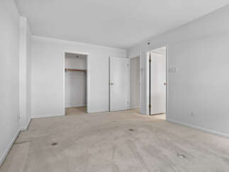 This spacious room features neutral carpeting and ample closet space, perfect for storage.