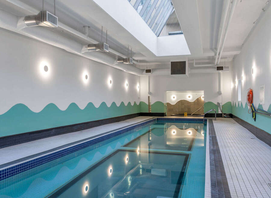 Dive into relaxation in this stunning indoor swimming pool, featuring a sleek design and ample natural light from the skylight above.