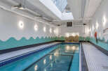 Dive into relaxation in this stunning indoor swimming pool, featuring a sleek design and ample natural light from the skylight above.