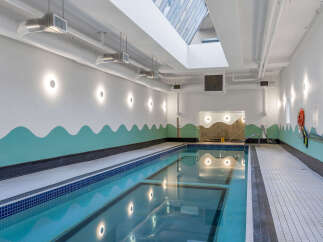 Dive into relaxation in this stunning indoor swimming pool, featuring a sleek design and ample natural light from the skylight above.