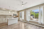 Experience modern living in this bright and airy condo featuring a sleek kitchen with ample cabinet space and a central island perfect for entertaining.