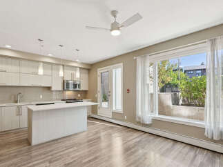 Experience modern living in this bright and airy condo featuring a sleek kitchen with ample cabinet space and a central island perfect for entertaining.