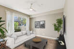 Experience modern living in this bright and airy living room, featuring a comfortable white sofa and a stylish dark wood coffee table.