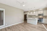 Experience modern living in this bright and airy open-concept space, featuring a sleek kitchen with stainless steel appliances and a convenient island.