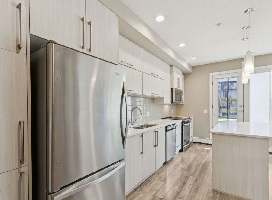 Experience modern living in this stunning kitchen featuring sleek, light wood cabinetry and stainless steel appliances.