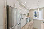 Experience modern living in this stunning kitchen featuring sleek, light wood cabinetry and stainless steel appliances.