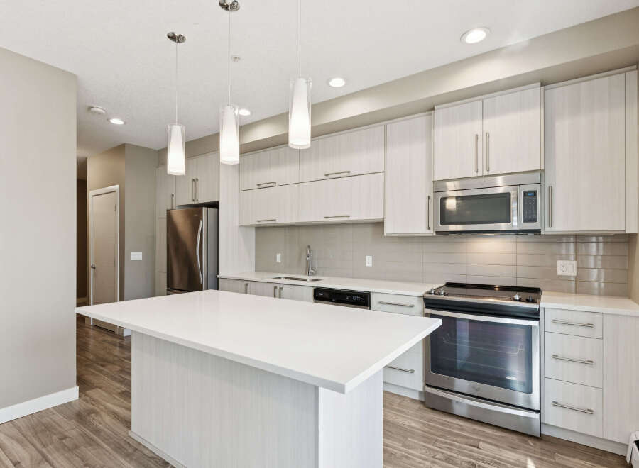 Experience modern living in this stunning kitchen featuring a sleek white island perfect for entertaining.