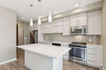 Experience modern living in this stunning kitchen featuring a sleek white island perfect for entertaining.