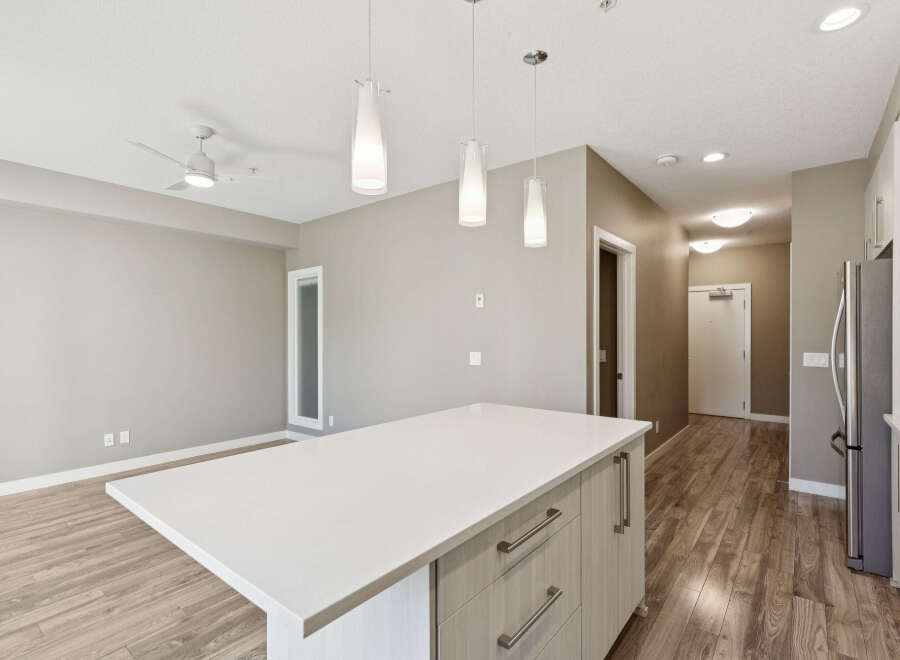 Experience modern living in this spacious open-concept condo, featuring a sleek kitchen island perfect for entertaining.