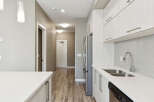Step into a modern kitchen featuring sleek white cabinetry and a gleaming stainless steel refrigerator.