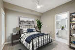 Experience modern comfort in this beautifully appointed bedroom, featuring a stylish metal-frame bed with elegant striped bedding and a cozy navy throw.
