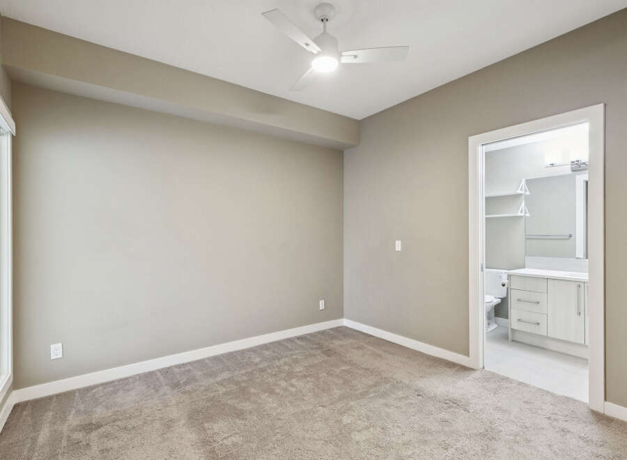 Step into this inviting bedroom featuring plush carpeting and a modern ceiling fan for year-round comfort.